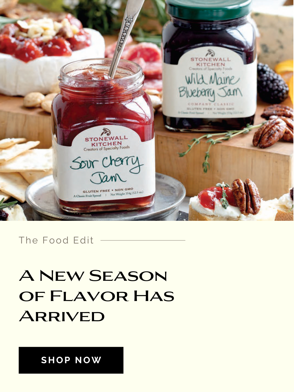 Stonewall Kitchen jam jars with food items on a wooden board, featuring text 'A New Season of Flavor Has Arrived'.